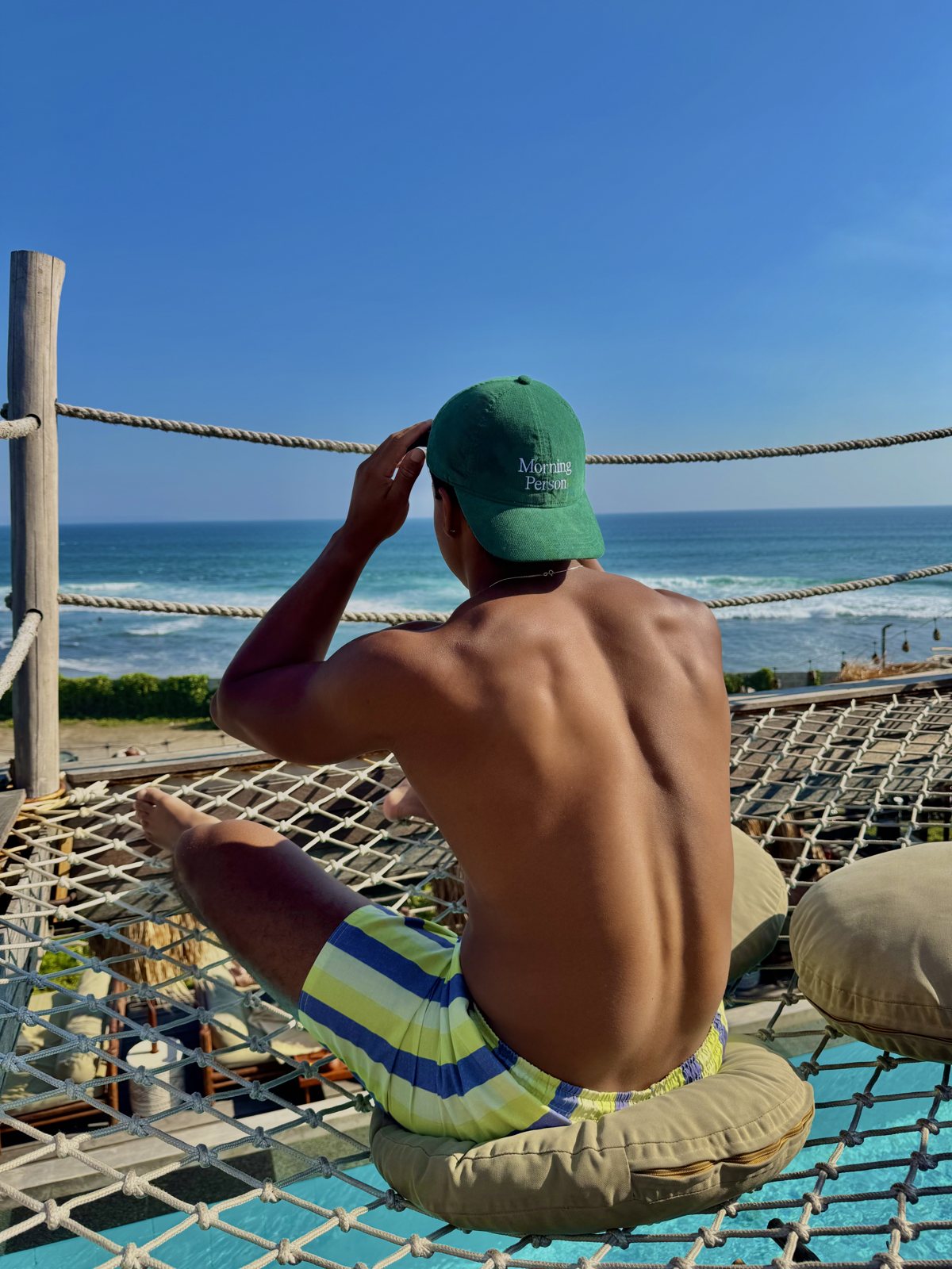 Maximus in a green cap overlooking the ocean in Bali